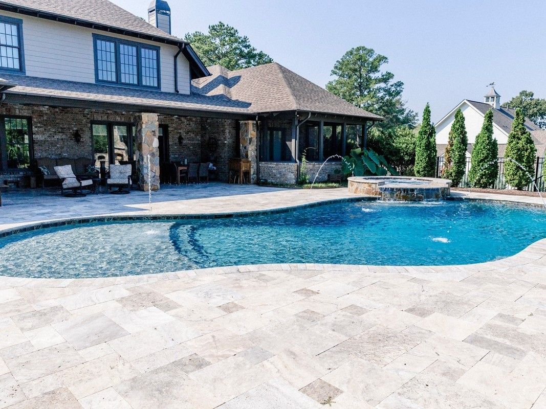 Gunite pool with a spillover spa and an outdoor fireplace